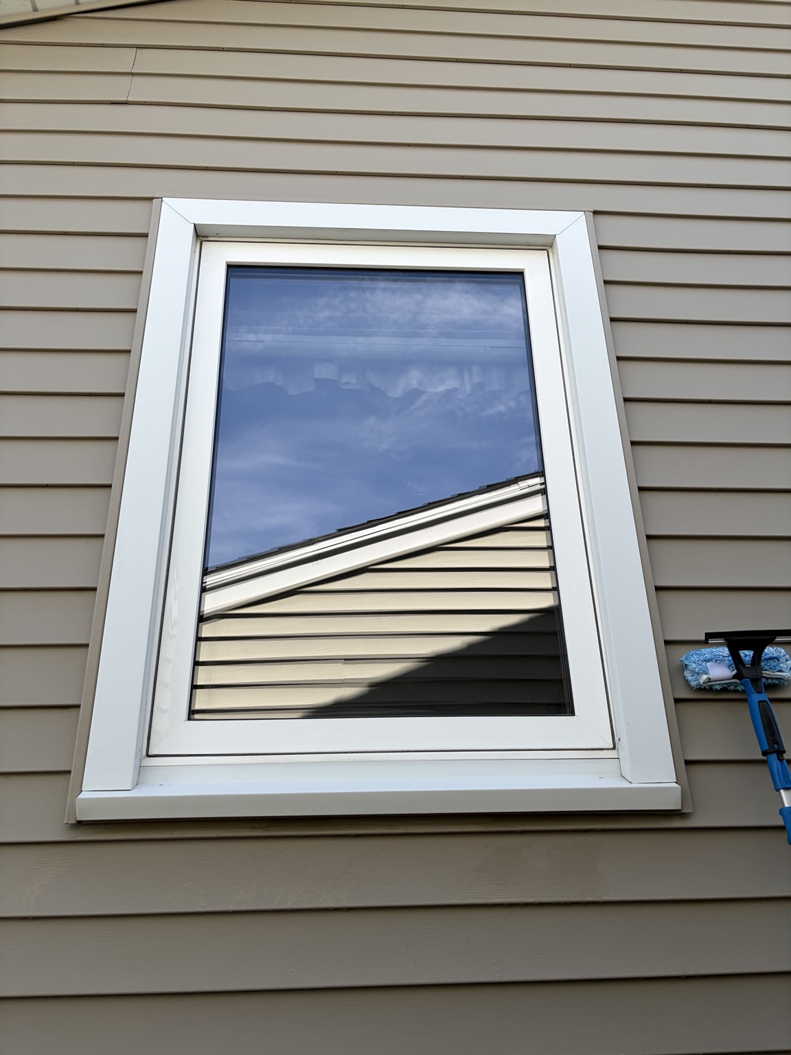 Spotless residential window reflecting blue sky